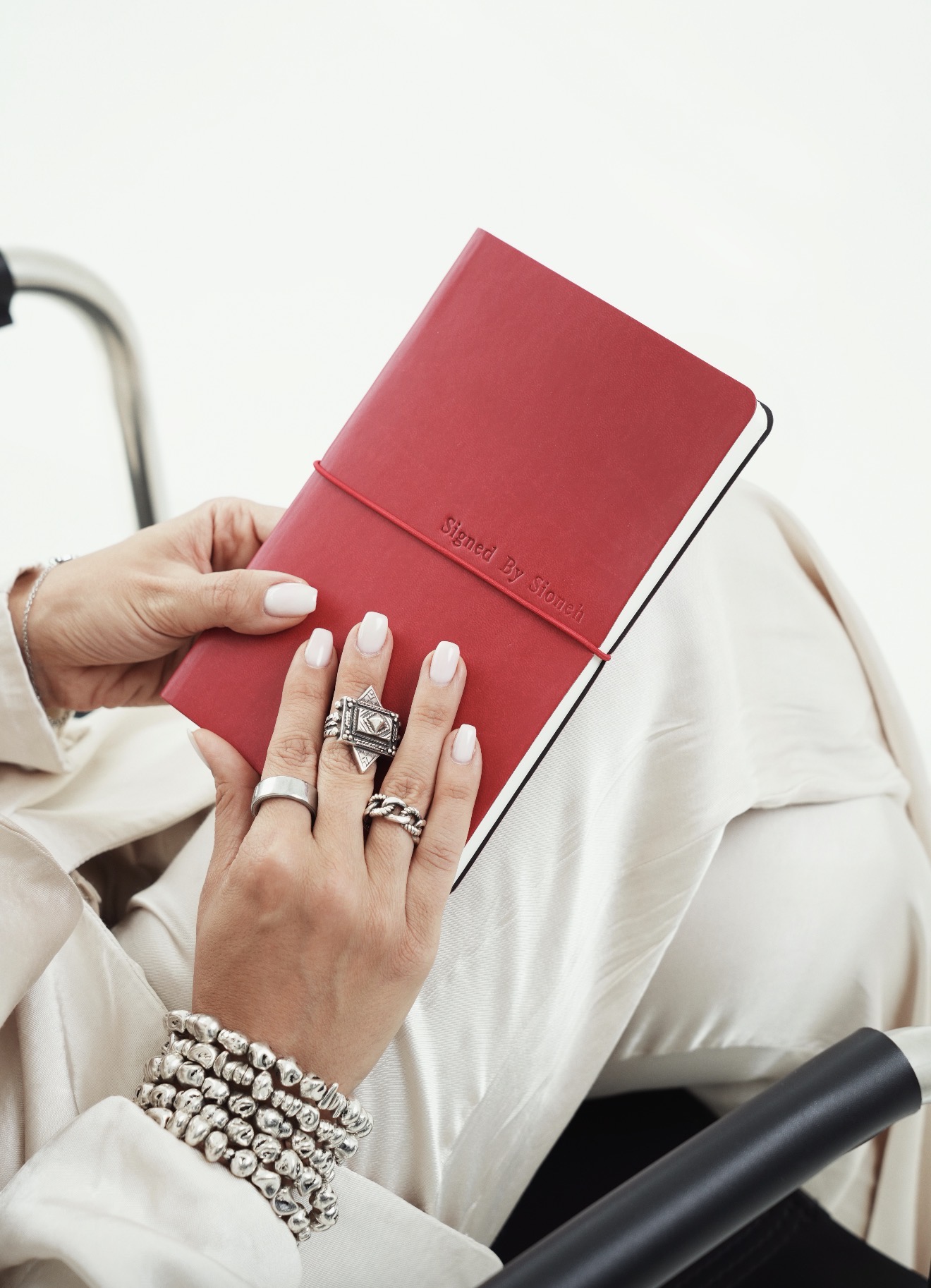 Burgundy Signed by Sioneh notebook held in hand